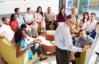 Image of employees sitting in circle during brainstorming session